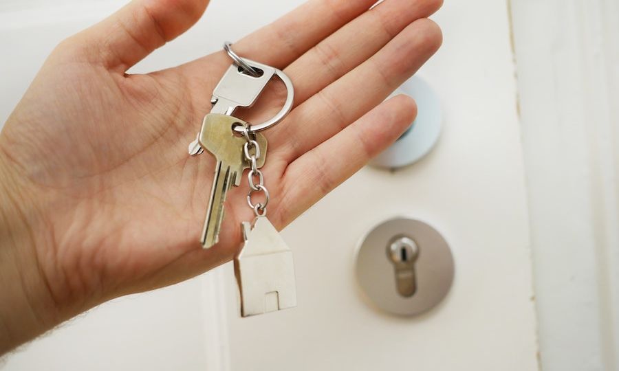 Manos con recibiendo las llaves de una casa heredada